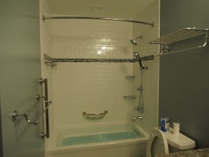 Curved shower curtain rods and corner shelves are installed as well.